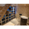 Aménagement cave à vin avec des range bouteille sous un escalier