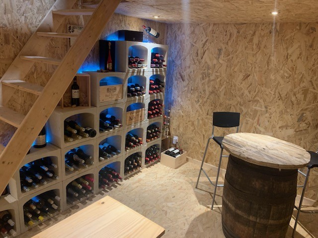 Aménagement cave à vin avec des range bouteille sous un escalier