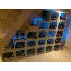 Aménagement de cave à vin moderne sous un escalier avec éclairage LED et casiers bouteilles en pierre KitCave